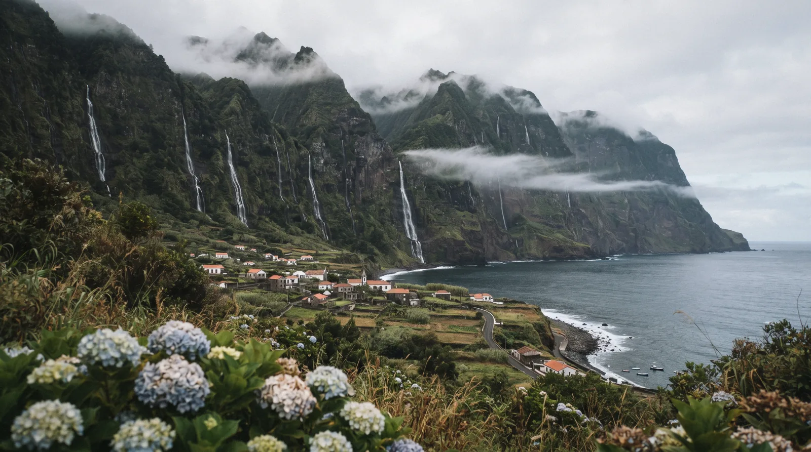 A wall of green waterfalls pouring down a cliff face above Fajã Grande on Flores island in the Azores