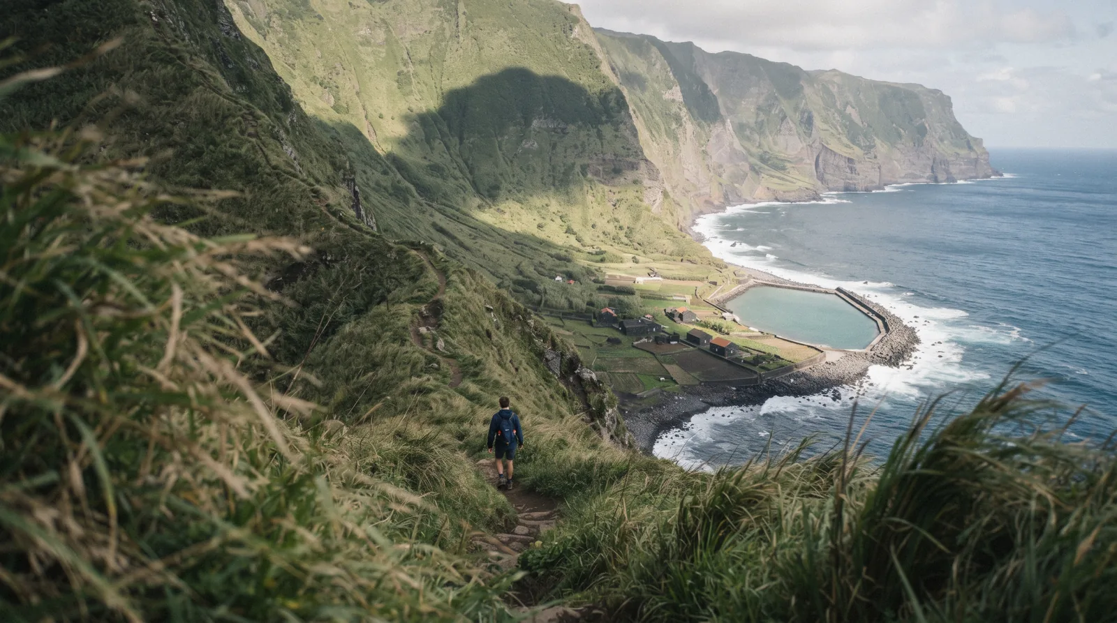 Green coastal platforms at the foot of a steep cliff line on the north coast of São Jorge island in the Azores