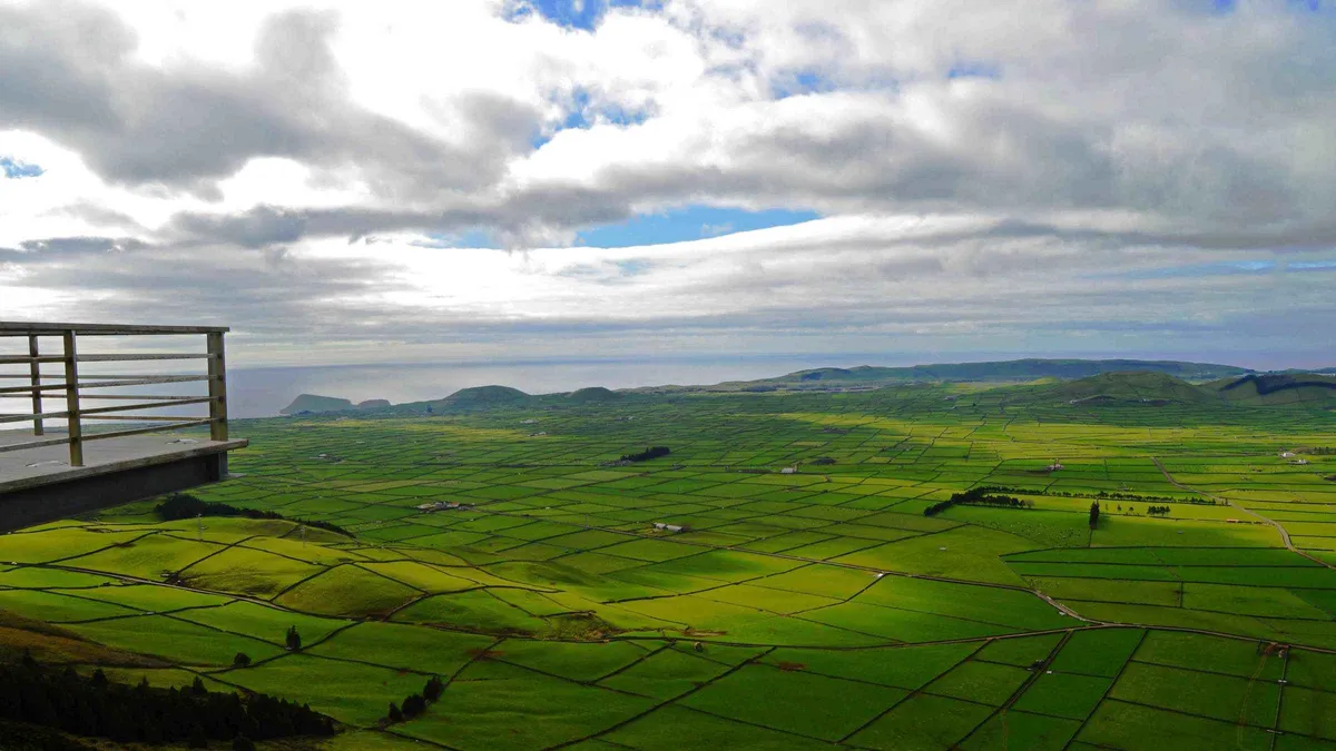 A viewpoint walkway over the patchwork green fields of the Serra do Cume on Terceira island