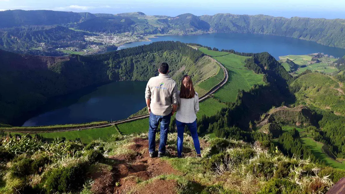Two travelers at a rim viewpoint over the crater lakes of Sete Cidades on a small-group van tour