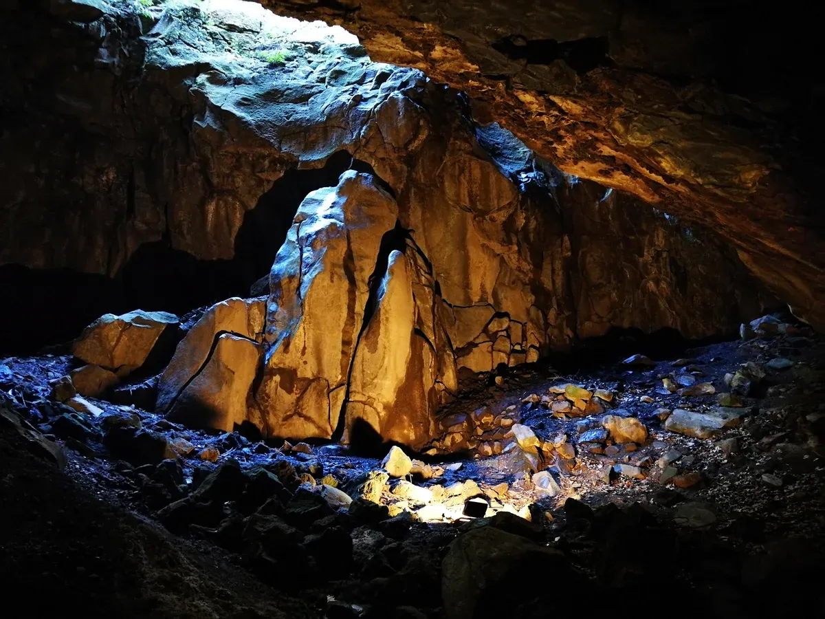 The interior of the Furna do Enxofre cave on Graciosa, daylight entering through the crack above the boulders