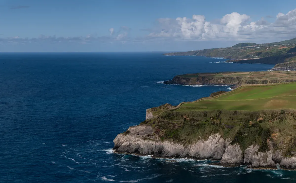 The north coast of São Miguel seen from the Miradouro de Santa Iria, green headlands and cliff ledges meeting the Atlantic